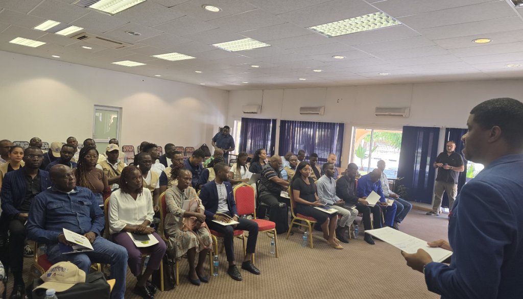 Orador discursando para audiência, sentada num auditório